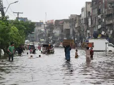 epa11515513 People and vehicles make their way through a water-logged street after heavy rainfall in Lahore, Pakistan, 01 August 2024. Lahore experienced heavy monsoon rains on Thursday, with 350 millimetres recorded in just three hours, shattering a 44-year-old rainfall record, MET office said. The downpour caused significant flooding in various areas, including Mall Road, Ferozepur Road, and Model Town, while rainwater inundated homes in Tajpura and disrupted operations at Services Hospital. The Lahore Electric Supply Company reported widespread power outages due to 288 tripped feeders, urging consumers to be patient as restoration efforts were underway. The Pakistan Meteorological Department warned of more torrential rains expected across the upper regions of the country from August 01 to 06. EPA/RAHAT DAR