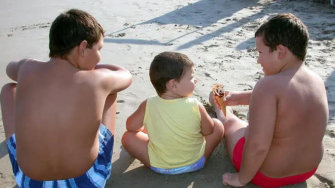 20050509 - ROMA - CRO - OBESITA': BAMBINI EUROPEI, TUTTI A LETTO SENZA SPOT. RAPPORTO EUROPEO, NO A PUBBLICITA' TV SU ALIMENTI NON SALUTARI. Una immagine di archivio mostra tre bambini paffutelli su una spiaggia ligure. Bambini europei: tutti a letto senza spot! E' quanto propone il rapporto sulla prima fase del progetto 'Bambini e obesita', la ricerca dell'European Heart Network (EHN) condotta in 20 Paesi europei tra i mesi di maggio e novembre 2004, riguardante la diffusione e la natura del marketing rivolto ai bambini per cibi ad alto contenuto di grassi, zuccheri e sodio. Rapporto discusso oggi a Milano nell' ambito di un convegno promosso dall' Associazione per la lotta alla trombosi (ALT). SILVIO FASANO/ARCHIVIO - ANSA - KRZ