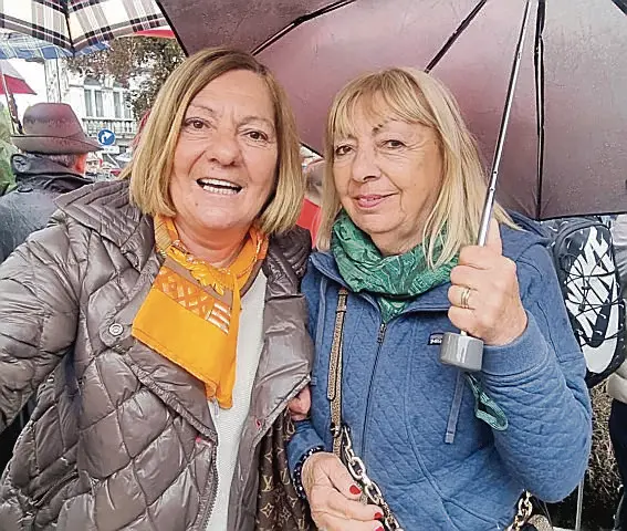 Le due amiche Gloria Martini, 71 anni, e Giuliana Frattini, 73, aspettano i loro mariti che sfilano con gli alpini della Val di Susa