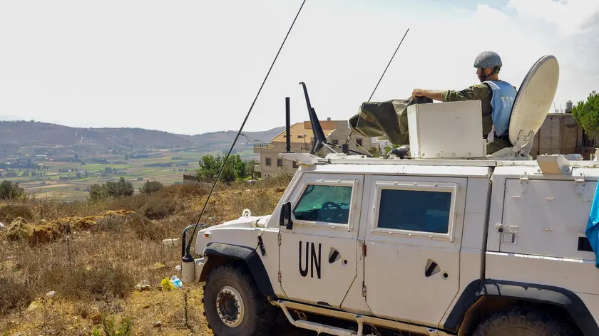 epa11566889 A soldier of the UN peacekeeping mission, United Nations Interim Force in Lebanon (UNIFIL), keeps watch from Marjayoun area opposite Lebanese Khiyam town and Israeli Metula settlement, near the Lebanon-Israel border in southern Lebanon, 27 August 2024. Hezbollah announced in a statement on 25 August that the group launched an aerial operation with numerous drones targeting Israeli territory as the 'phase one' of a retaliatory attack for the killing of senior Hezbollah commander Fuad Shukr on 30 July in Beirut. The Israeli Defense Forces (IDF) said some 100 fighter jets struck and destroyed thousands of Hezbollah rocket launcher barrels, aimed for immediate fire toward northern and central Israel. EPA/STR