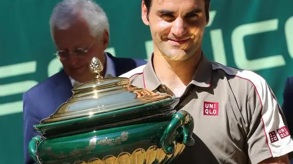epa07668073 Roger Federer from Switzerland celebrates with the trophy after winning the final match against David Goffin from Belgium at the ATP Tennis Tournament Noventi Open (former Gerry Weber Open) in Halle Westphalia, Germany, 23 June 2019. EPA/FOCKE STRANGMANN