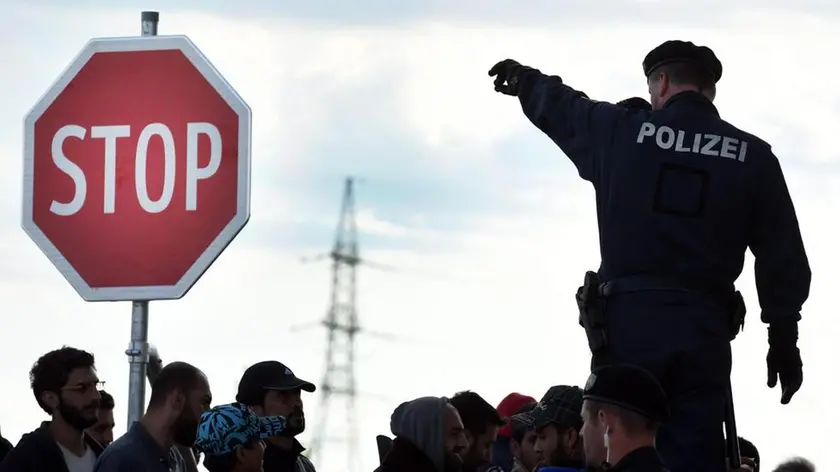 An Austrian police officer directs a group of refugees coming through Hungary at the Hungarian-Austrian border station in Nickelsdorf, Austria, 20 September 2015. Austrian police have started denying entry to some migrants trying to cross its southern border with Slovenia, a police spokesman in Styria province said 20 September. About 100 people were not let in from Slovenia during the night because they neither claimed asylum nor presented proper travel documents at the Spielfeld border crossing, the spokesman said About 700 people entered Austria from Slovenia on the weekend while 7,000 new arrivals were expected Sunday morning alone at Nickelsdorf on the Hungarian border, local Austrian police said. ANSA/HERBERT P. OCZERET