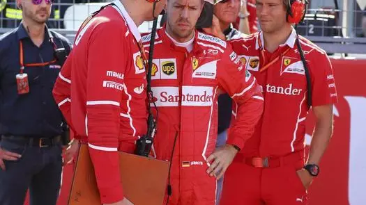 epa06252098 German Formula One driver Sebastian Vettel (C) of Scuderia Ferrari talks with a team member on the grid before the start of the Japanese Formula One Grand Prix at the Suzuka Circuit in Suzuka, central Japan, 08 October 2017. EPA/DIEGO AZUBEL