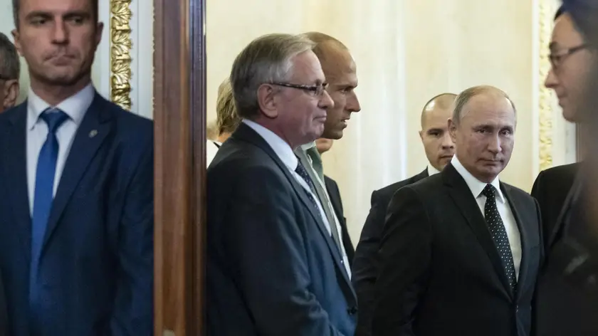 epa07032319 A Russian bodyguard (L) stands ready as President Vladimir Putin (R) enters a hall for a joint news conference with Hungarian PrimeViktor Orban after their talks in the Kremlin in Moscow, Russia, 18 September 2018, (issued 19 September 2018). Putin says 'a chain of tragic circumstances' is to be blamed for a Russian military aircraft shot down by a Syrian missile. He vowed to boost security for Russian troops there. EPA/ALEXANDER ZEMLIANICHENKO / POOL