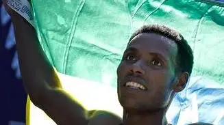 epa07141476 First place finisher Lelisa Desisa of Ethiopia holds up the Ethiopian flag at the 2018 TCS New York City Marathon in Central Park in New York, New York, USA, 04 October 2018. EPA/PETER FOLEY